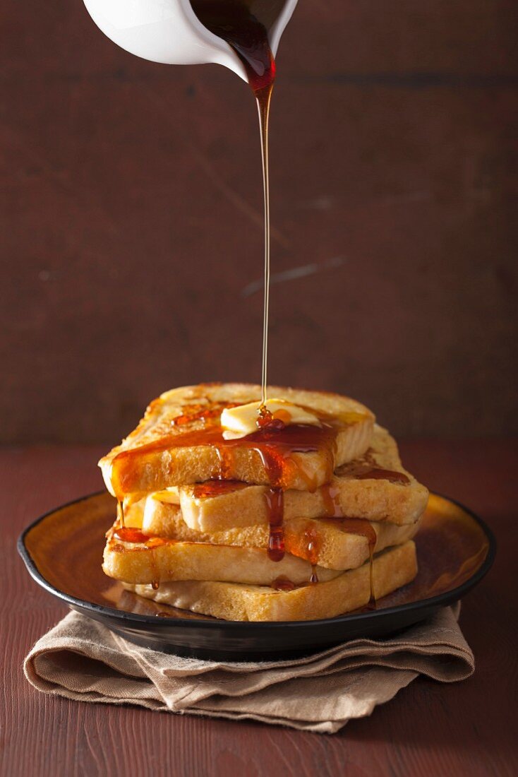 Caramel sauce being poured over French toast