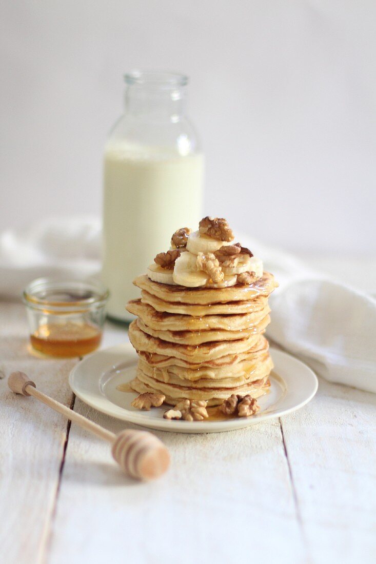 A stack of pancakes with bananas and nuts