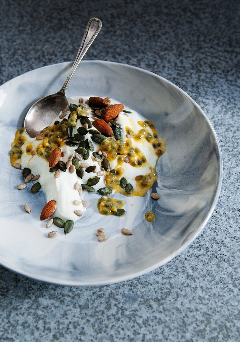 Yoghurt with passion fruit, almonds, sunflower seeds and pumpkin seeds