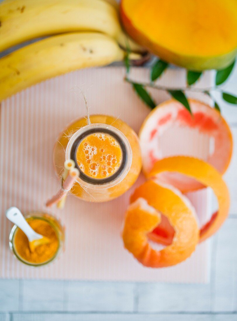 A yellow smoothie in a glass bottle