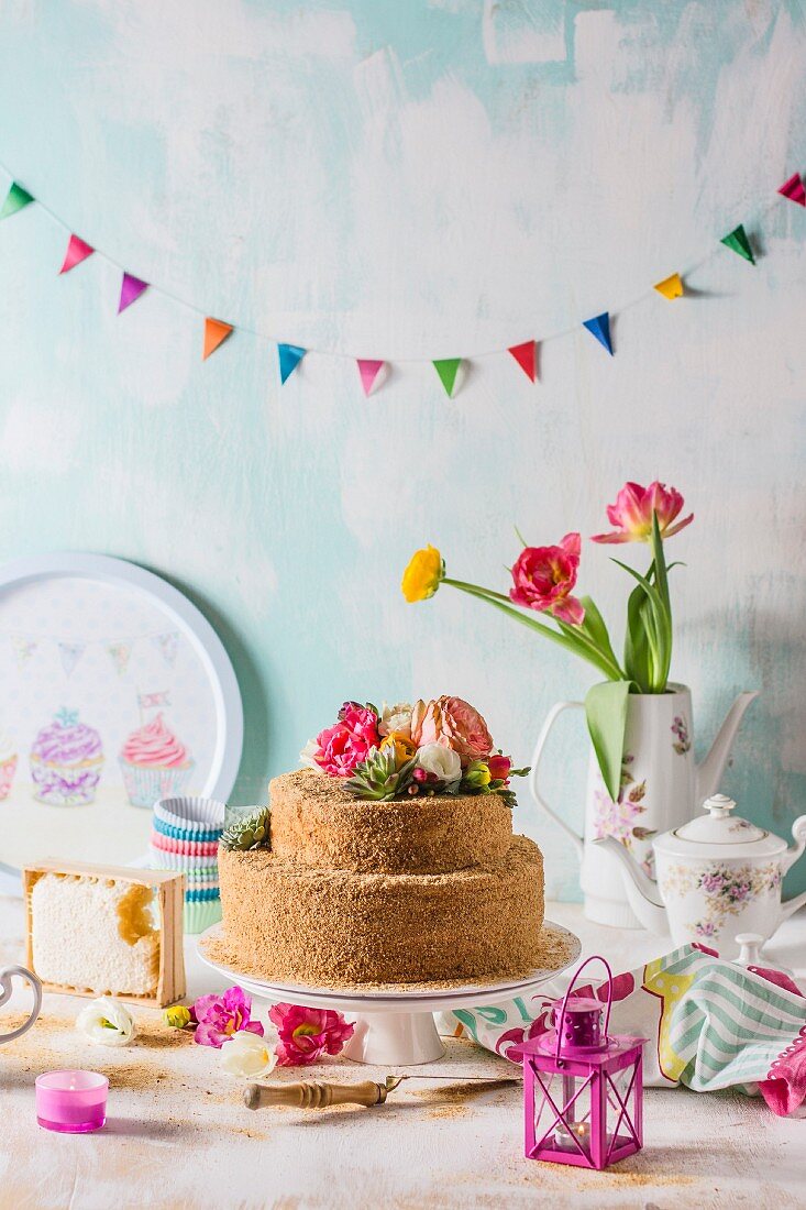 Russian honey cake decorated with flowers beneath colourful bunting