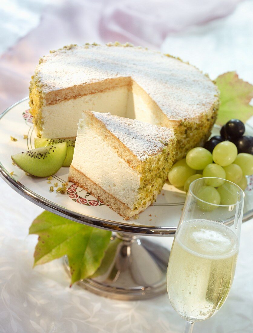 A creamy cheesecake garnished with kiwis and grapes