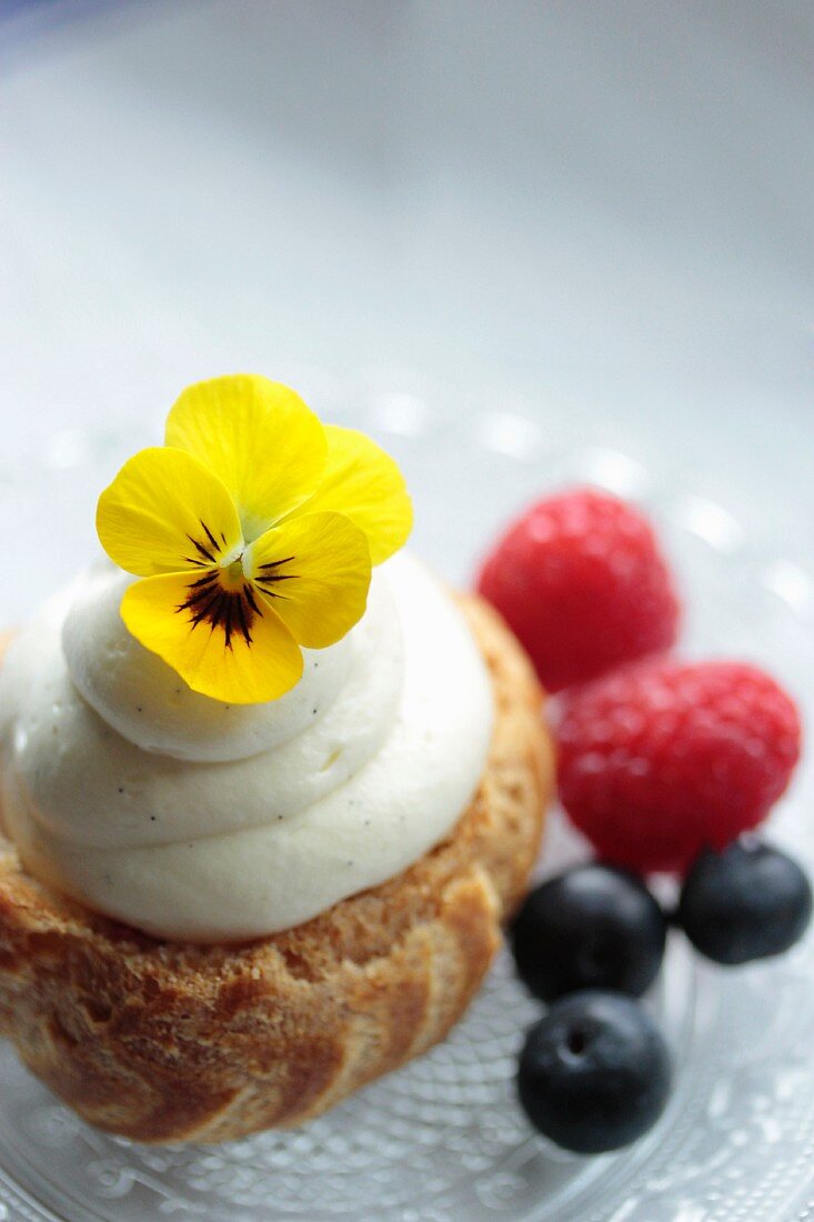 Chouquette with vanilla cream, berries and edible flowers