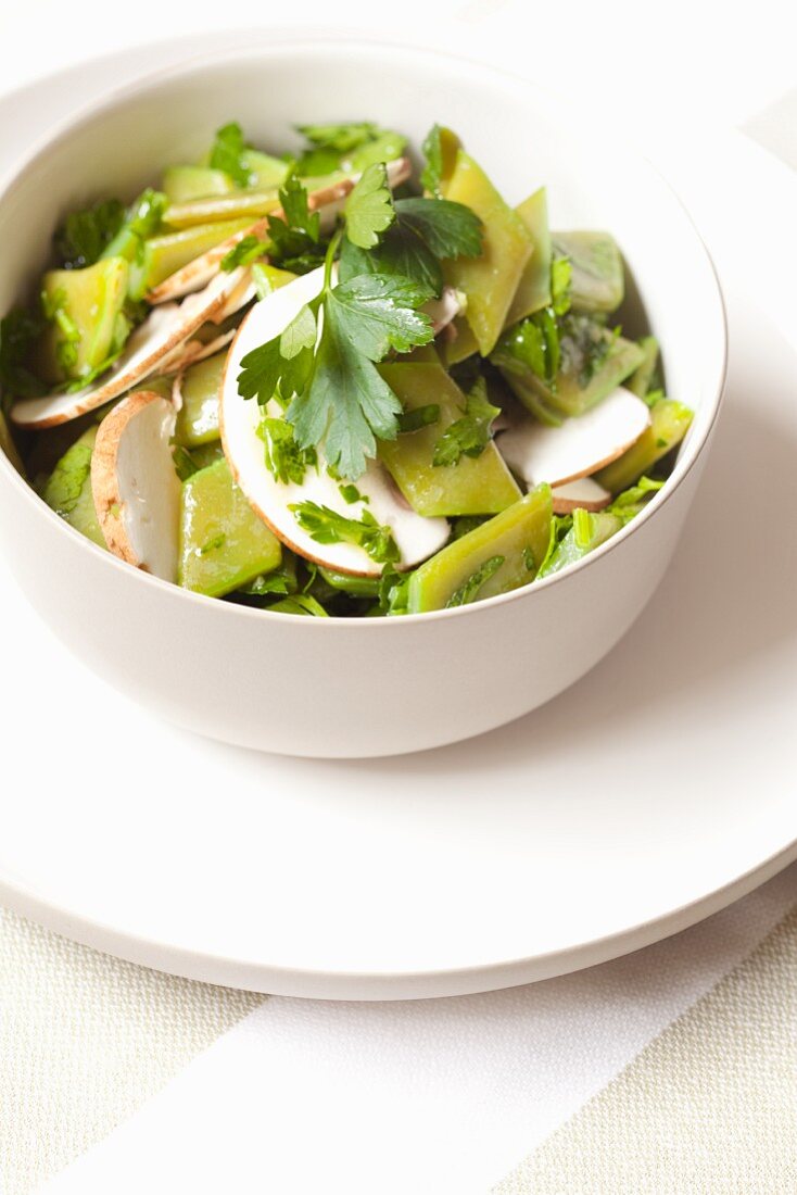 Bohnensalat aus flachen grünen Bohnen mit Pilzen und Petersilie