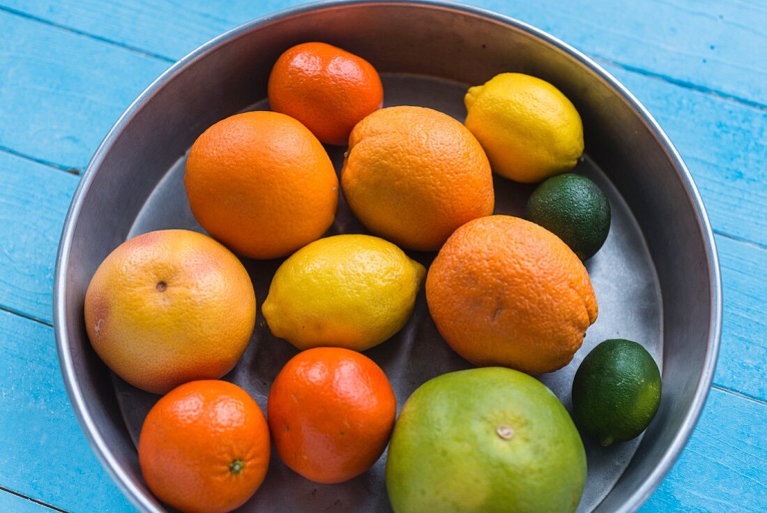 Various citrus fruits in a metal bowl