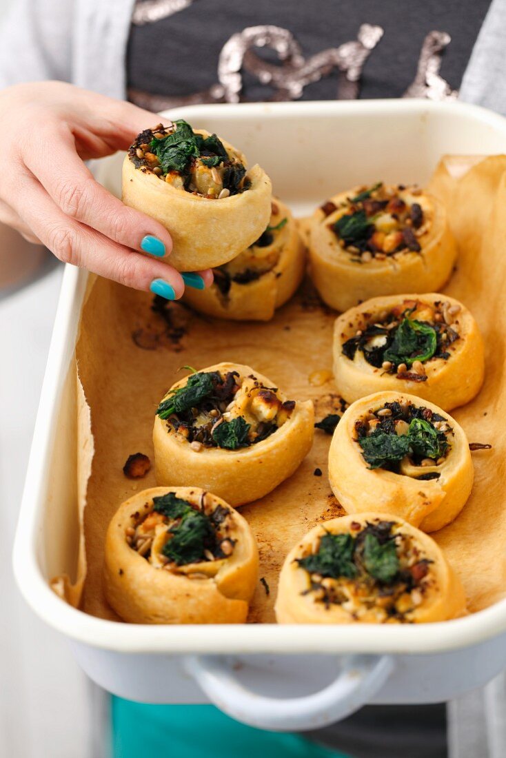 Pastries filled with spinach, ricotta and pine nuts in a roasting dish