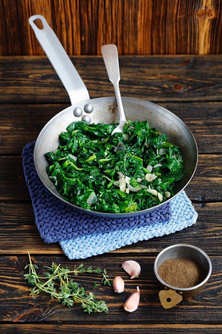 Steamed spinach with garlic and shallots in a pan