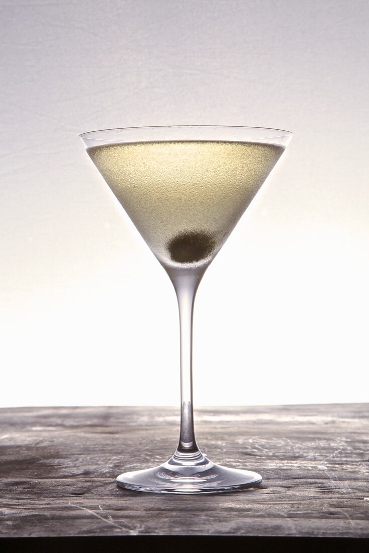 A martini with a caper berry