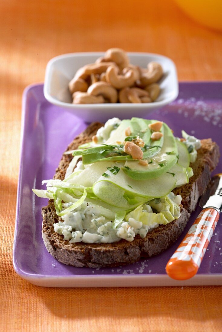 Dark bread topped with Roquefort, apples, avocado and cashew nuts