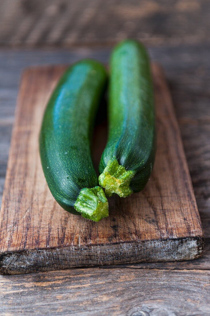 Two courgettes on a wooden board
