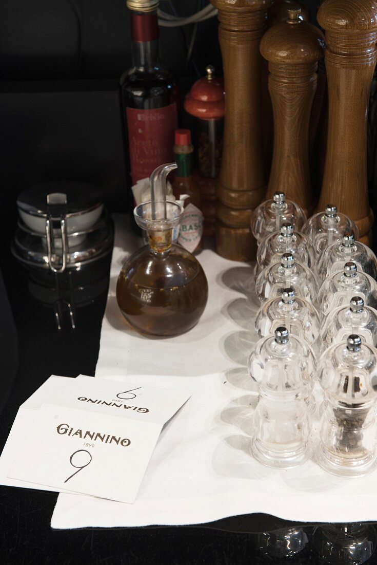A spice mill and a jug of oil in the restaurant 'Giannino', Milan, Italy