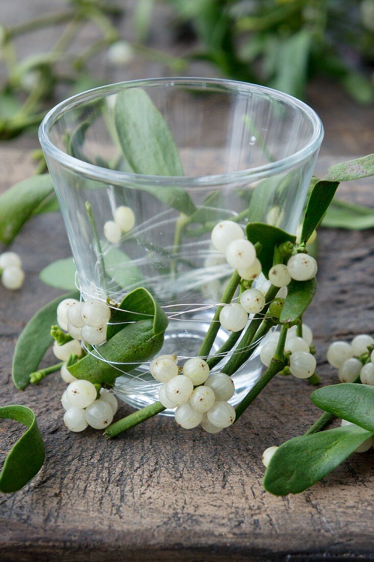 Glass tealight holder wrapped in mistletoe and wire