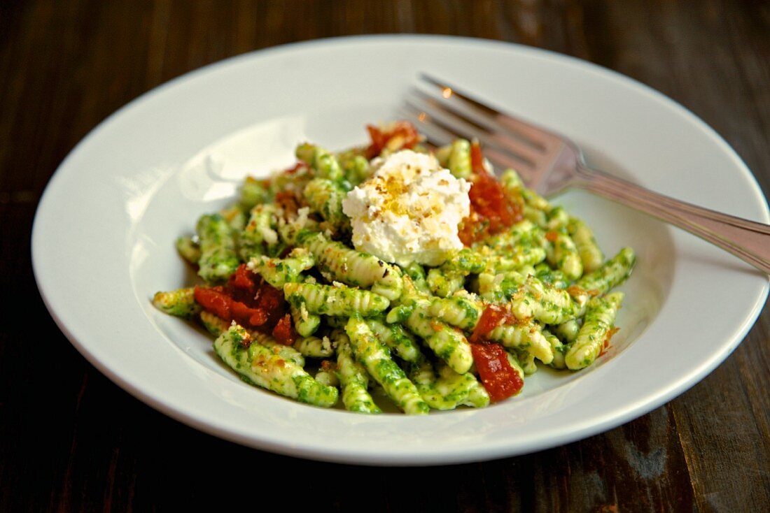 Fusilli pasta with pesto, dried tomatoes and ricotta cheese