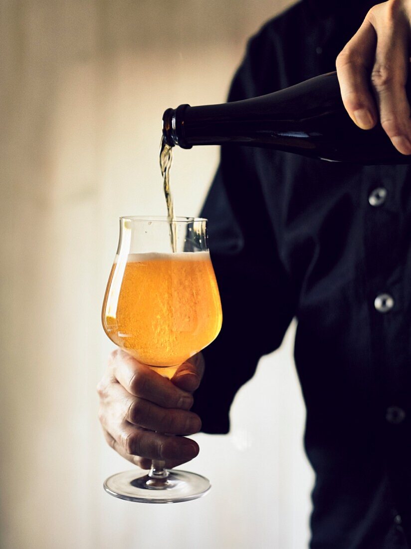 A man pouring a glass of India Pale Ale