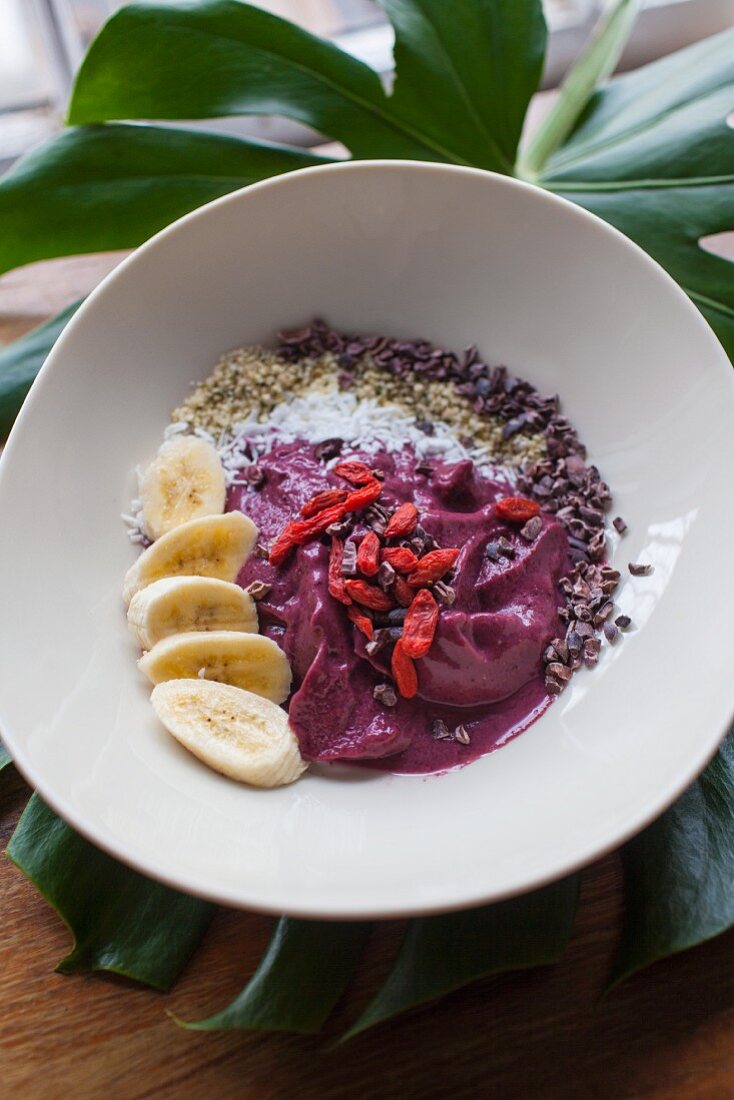 Homemade berry yogurt with fresh fruit, coconut, bananas and gogi berries