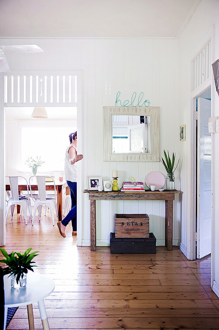 Living room with wooden floor and rural flair, woman in the background