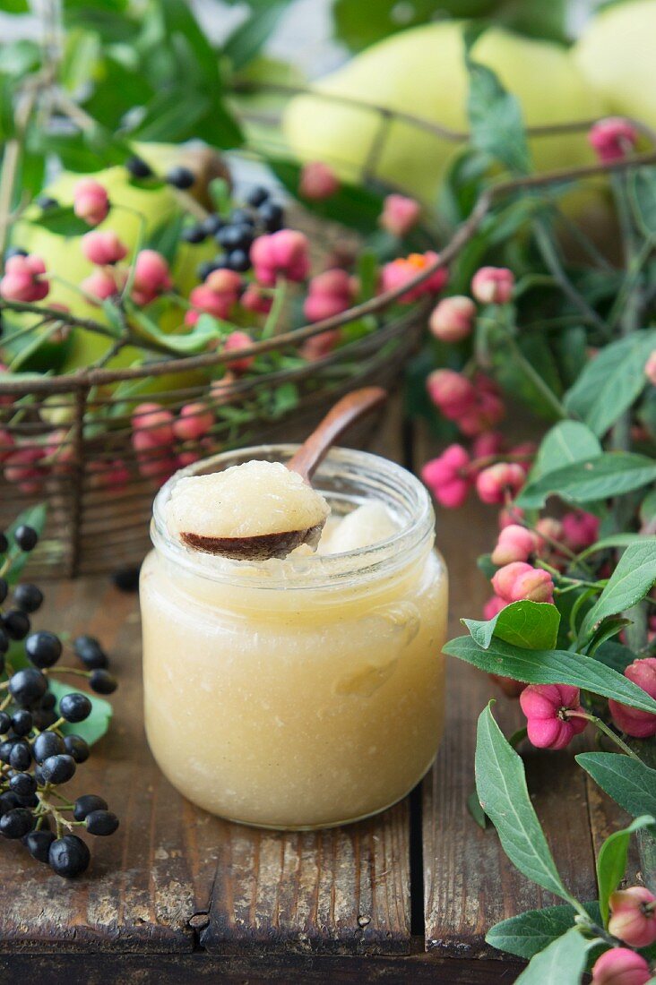 Quince sauce in a glass jar with a spoon