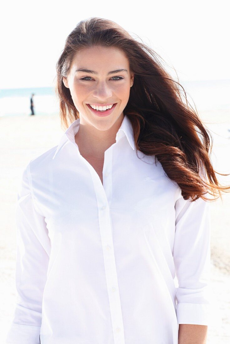 A young brunette woman wearing a white blouse