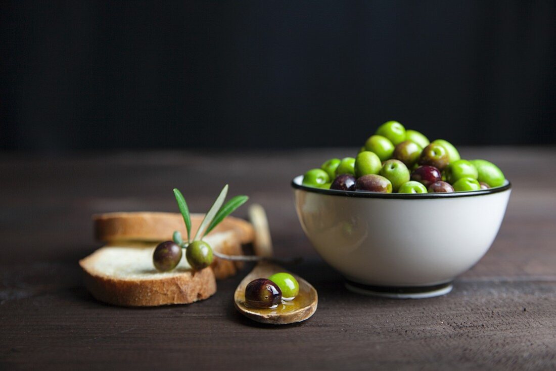 Lives in olive oil in a porcelain bowl and on slices of bread on a wooden table