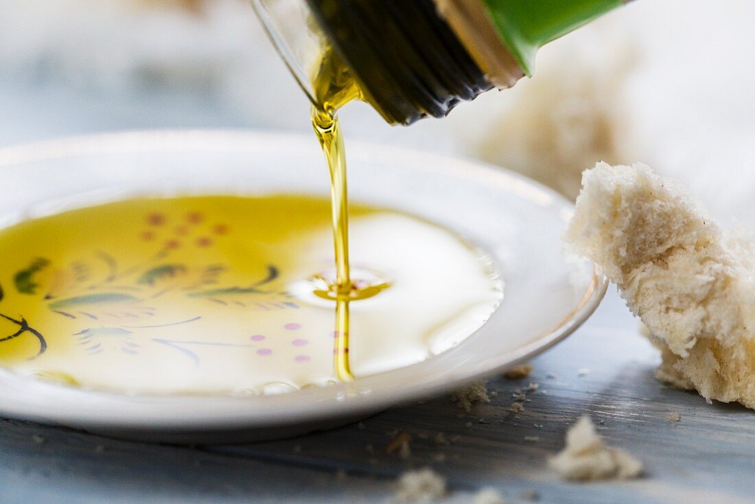 Olivenöl zum Dippen wird auf Teller gegossen