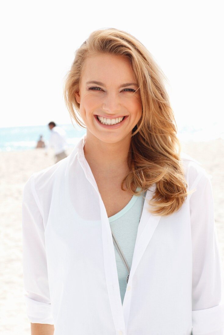 A young blonde woman wearing a white blouse