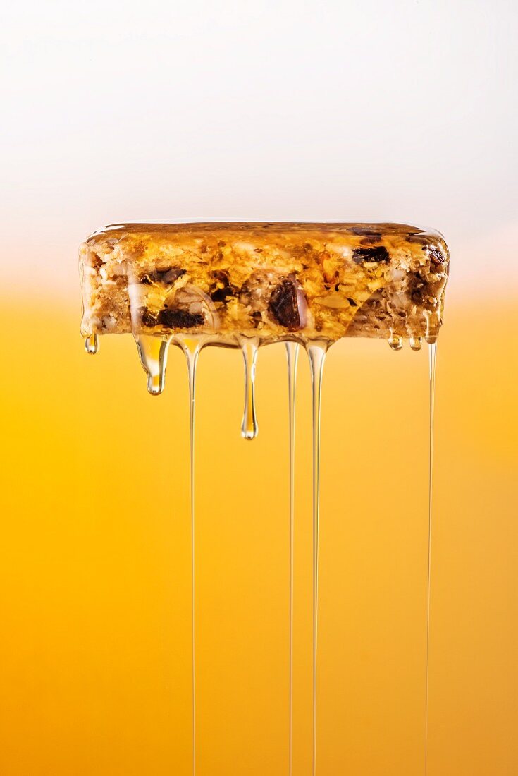 Honey being poured over a muesli bar