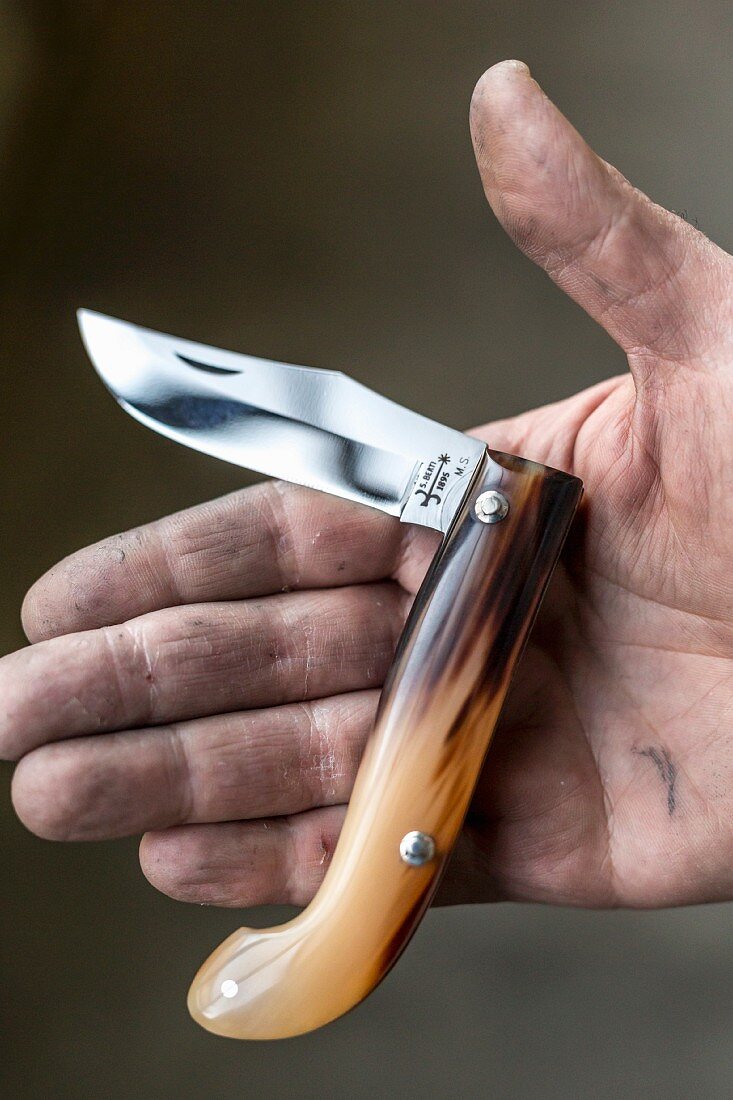 Someone holding a folding knife in an Italian knife factory