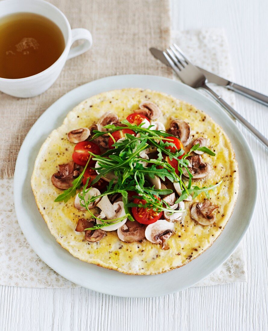 A healthy omelette with tomato, rocket and mushroom