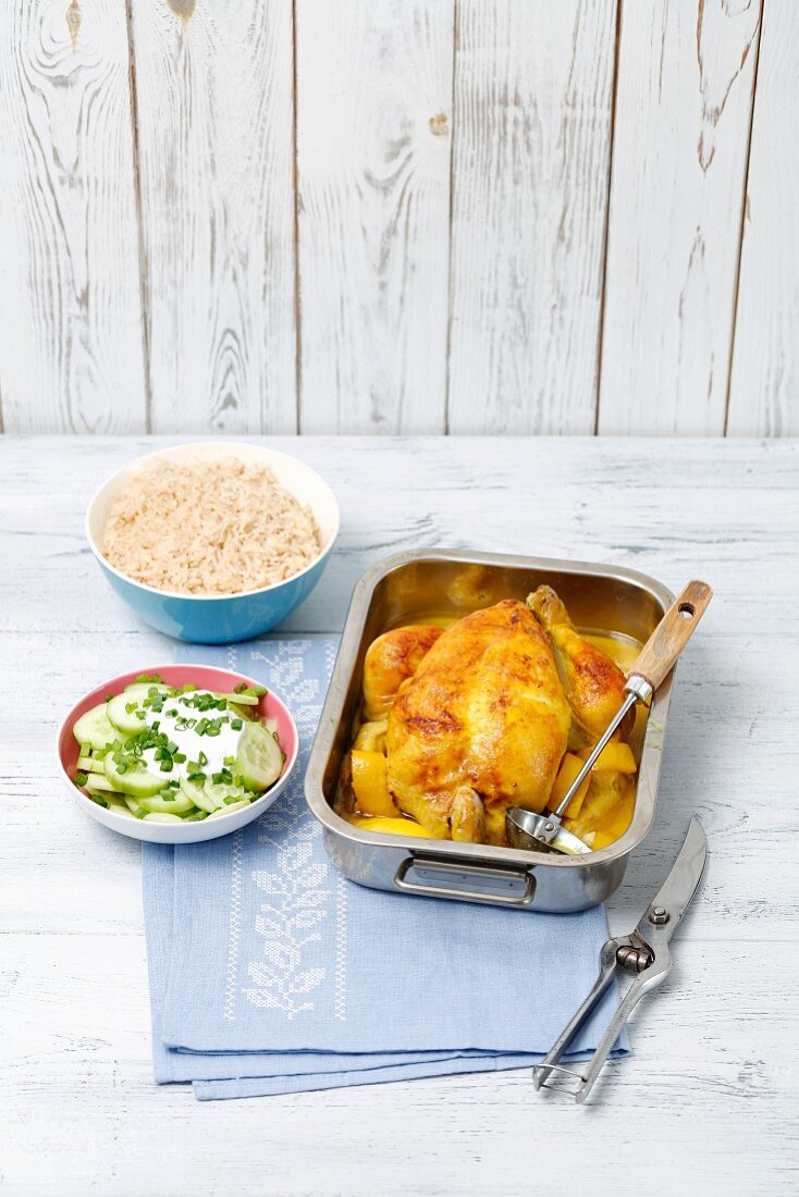 Lemon chicken in a roasting tin with rice and cucumber salad