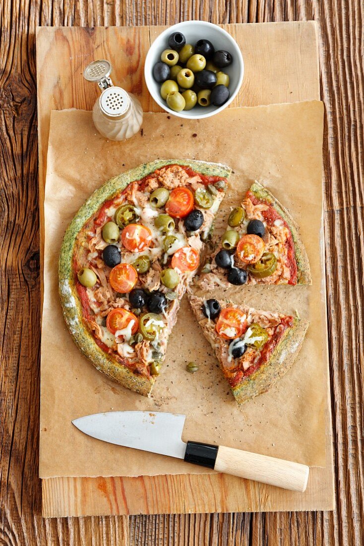 Grüne Pizza mit Thunfisch, Oliven, Jalapenos und Tomaten