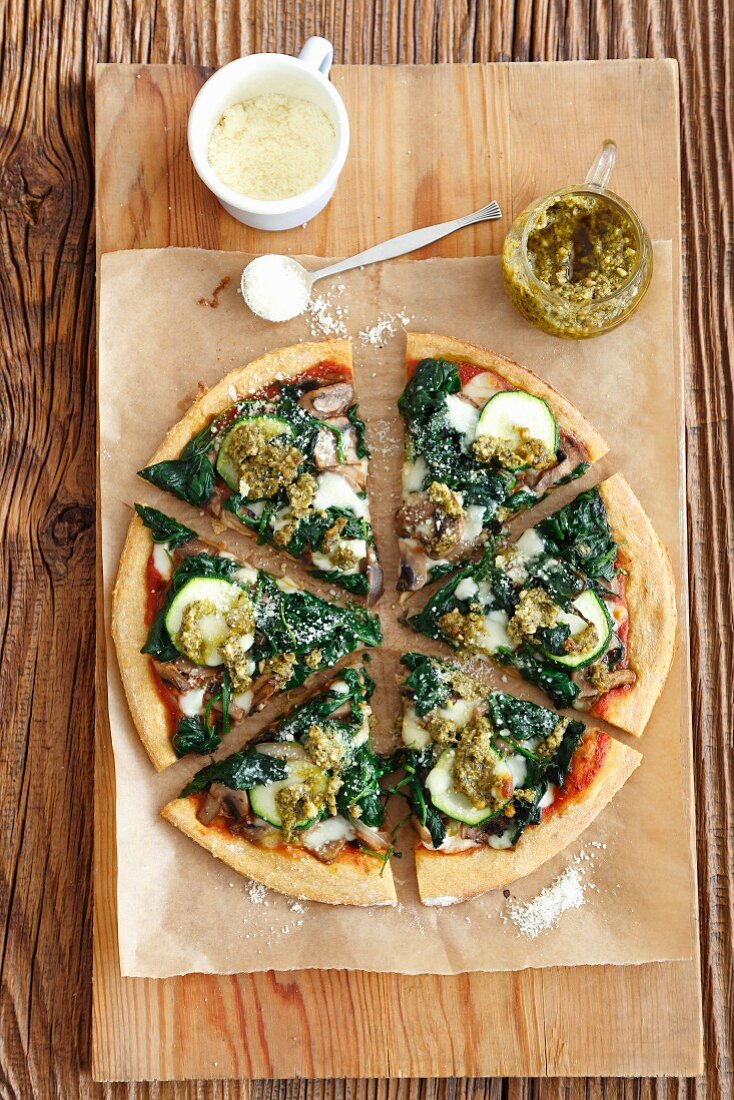 Vegetarische Pizza mit Spinat, Pilzen und Zucchini