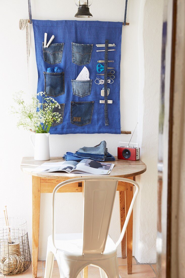 Sewing utensils in wall-mounted organiser made from old jeans pockets