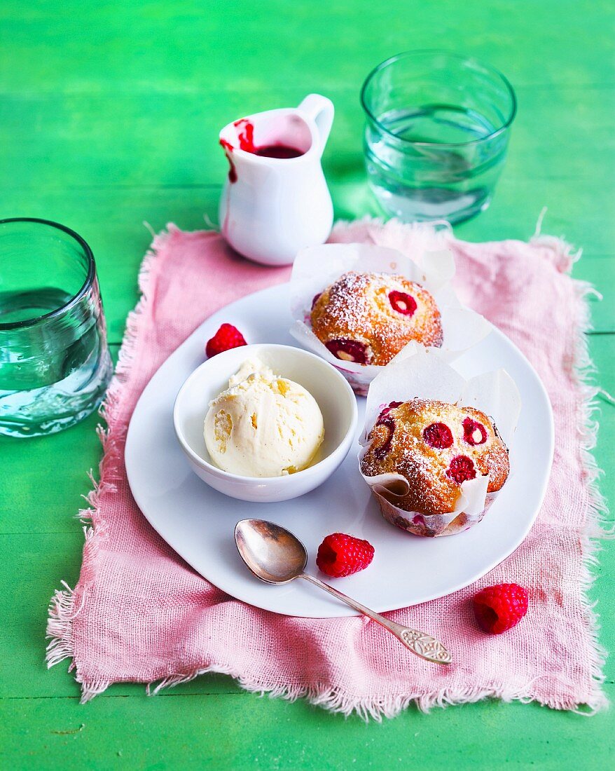 Raspberry muffins and vanilla ice cream served with raspberry sauce