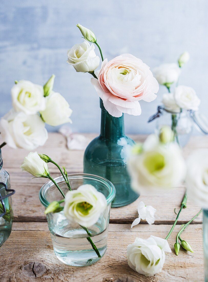 White eustomas and ranunculus in various vases