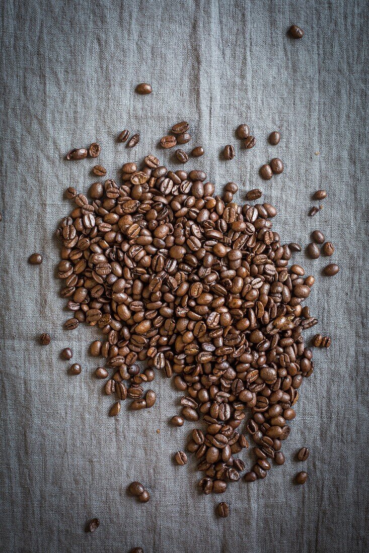 Kaffeebohnen auf grauer Leinendecke