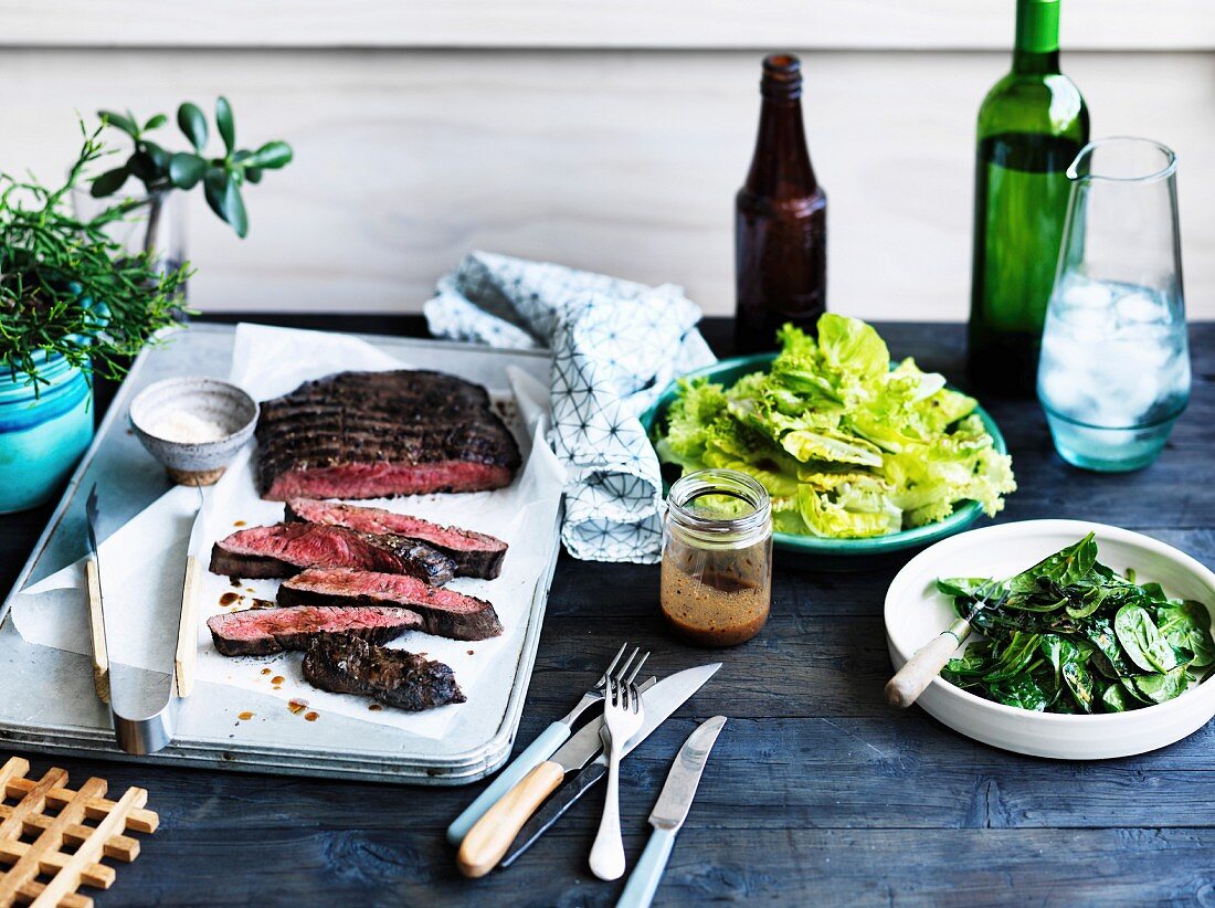 Rosa gegrilltes Flank Steak mit Blattspinat und grünem Salat