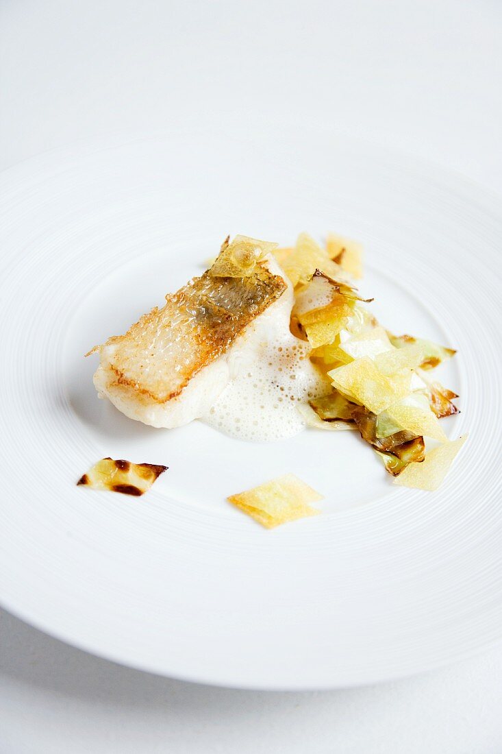 Crispy roast zander with a potato and cabbage medley and a white wine foam