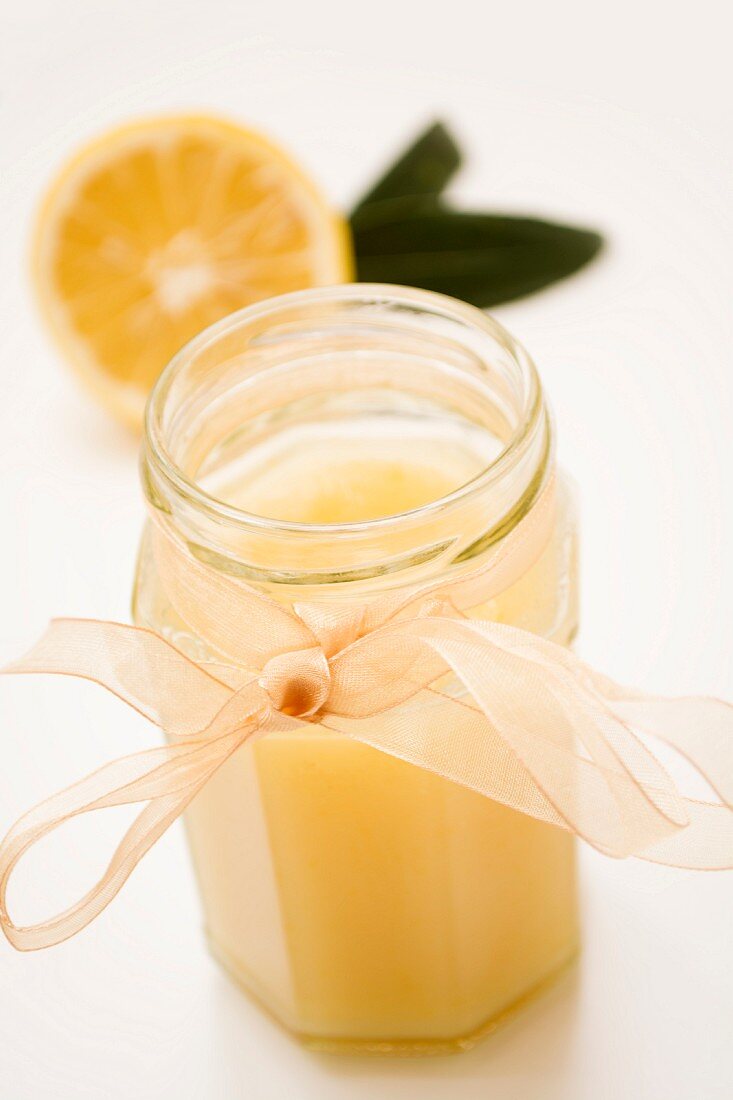 A jar of lemon curd with a chiffon ribbon