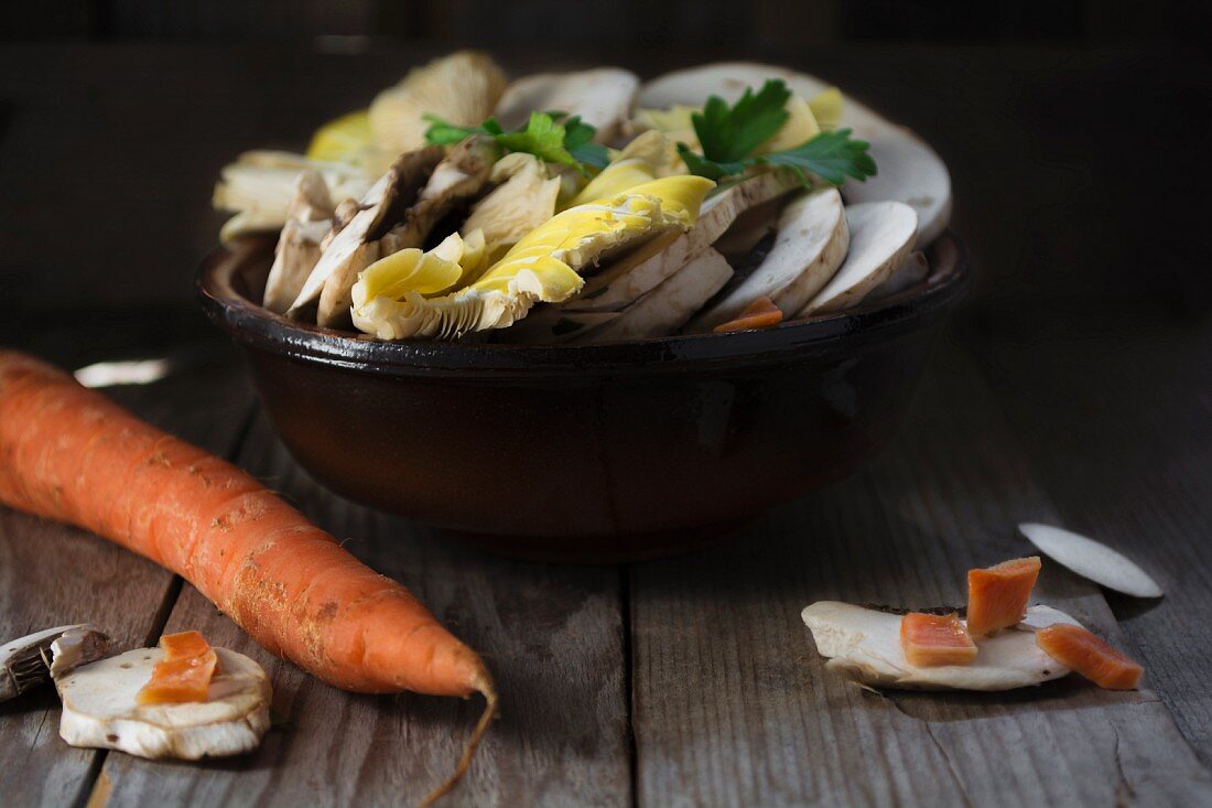 Raw, sliced mushrooms in a bowl on a wooden table