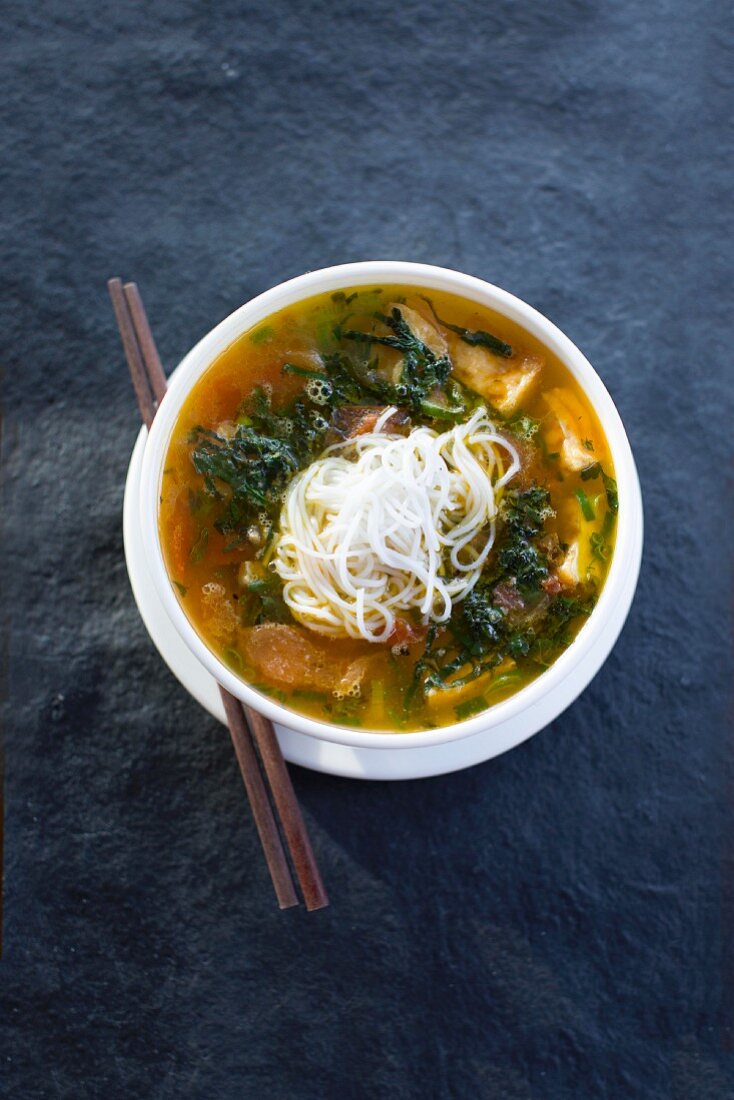 Pho (Vietnamese soup) with tofu, rice noodles, sea snails, plantains and bok choy