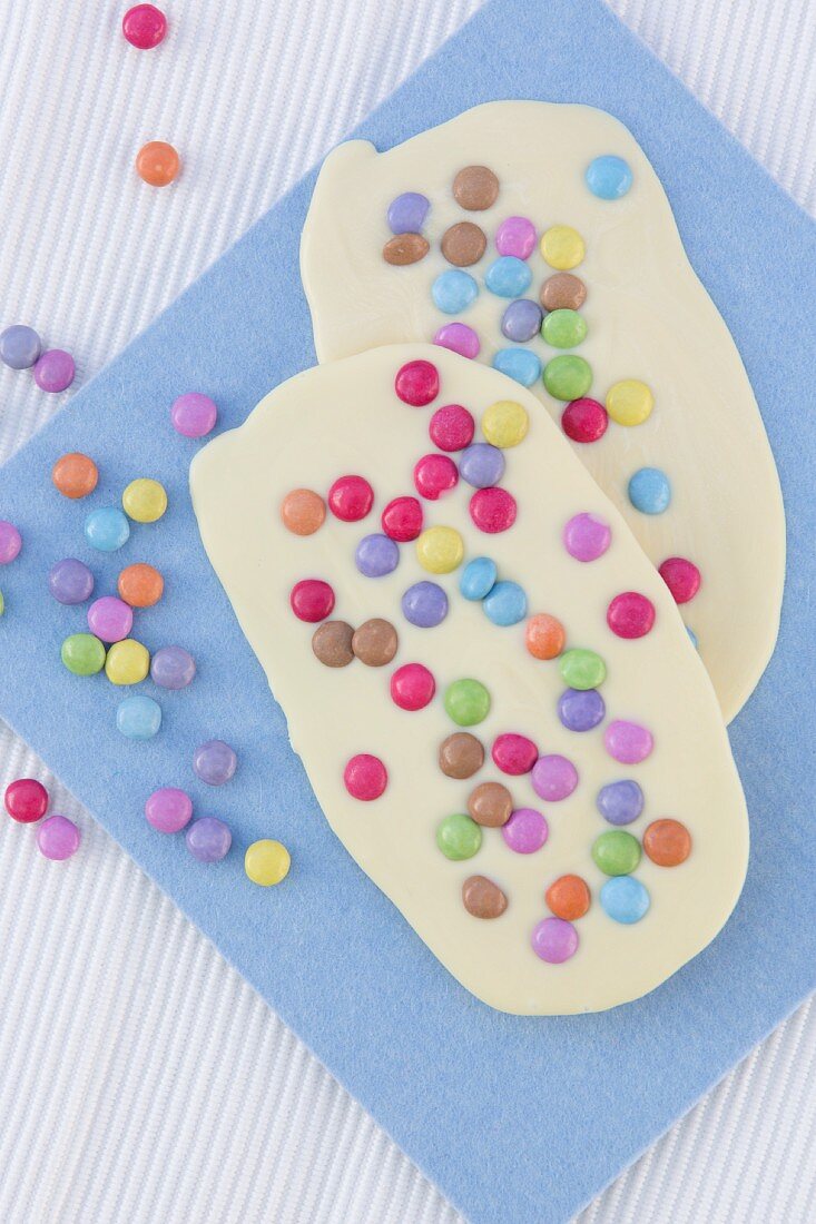 Two bars of white chocolate with colourful chocolate beans