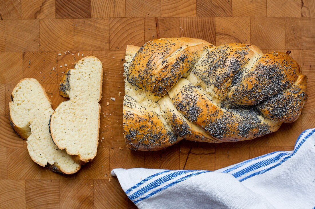 A poppyseed plait, sliced, on a wooden surface