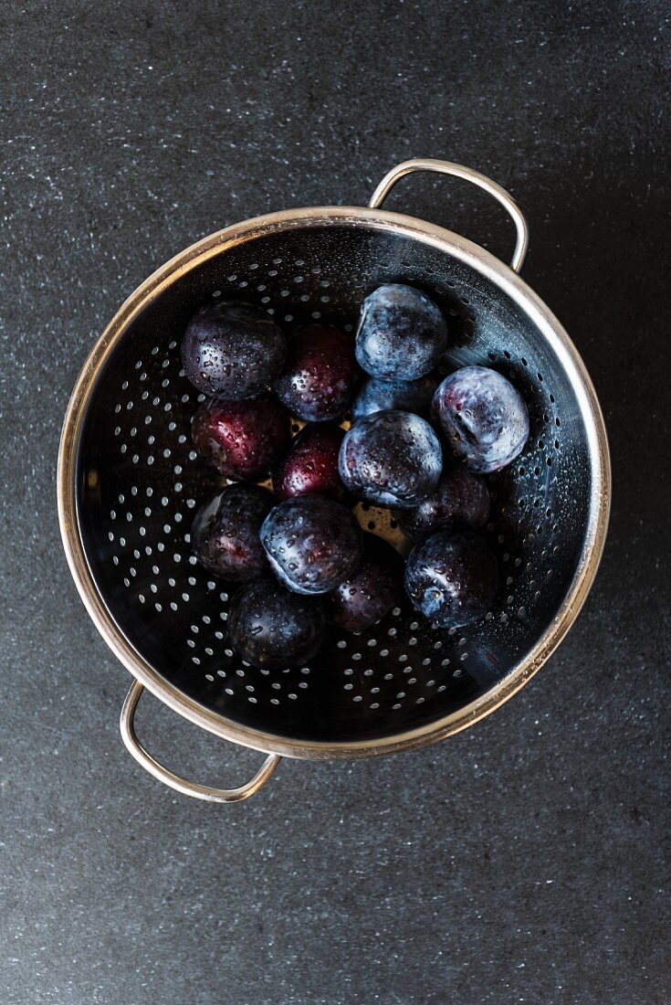 Fresh plums in a colander