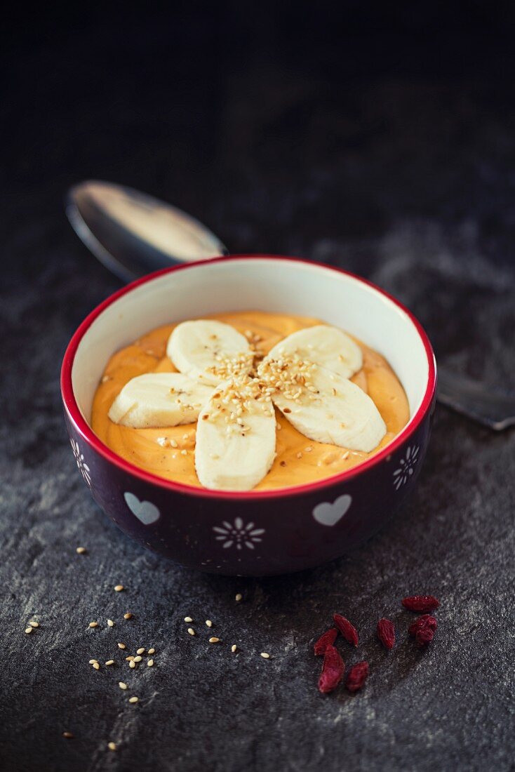 A smoothie bowl with goji, bananas and sesame seeds