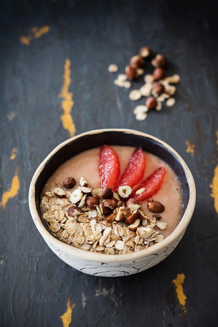 A smoothie bowl with grapfeuit, spelt flakes and hazelnuts