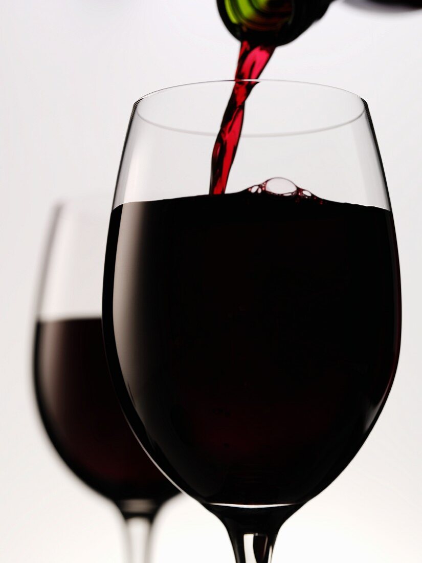 Pouring red wine into glass (close-up)