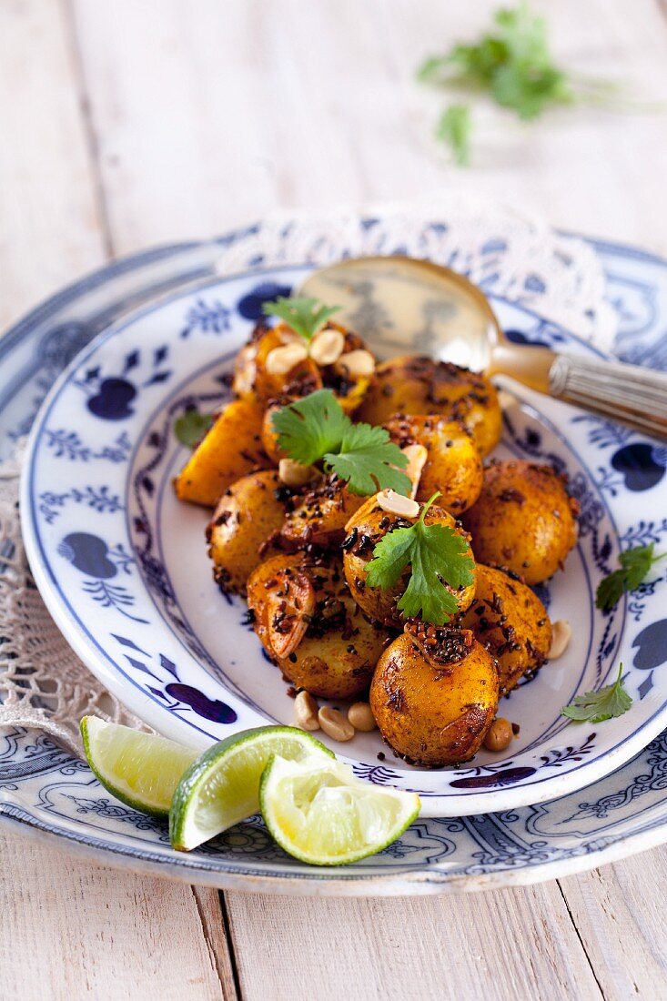 Fried potatoes with fenugreek, caraway, coriander, peanuts, black mustard seeds and limes