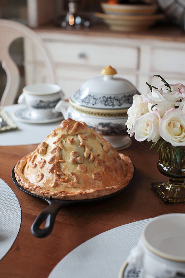 Kurnik (chicken pie with mushrooms, kasha and eggs, Russia), on a laid table