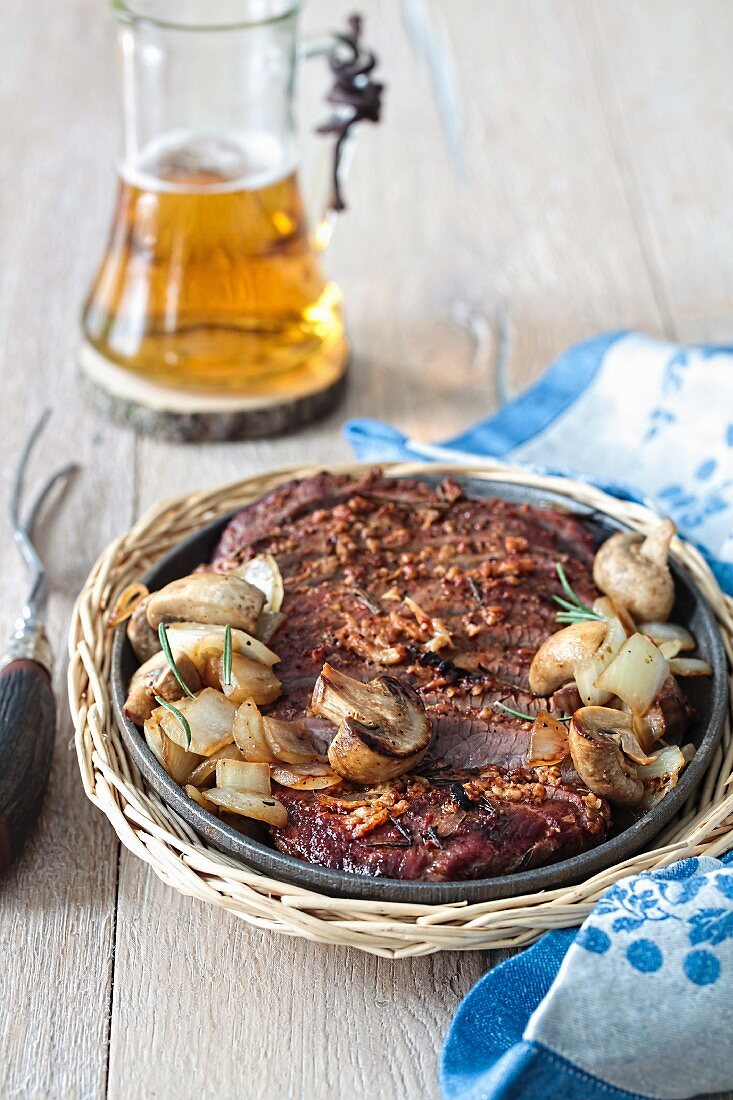 Whisky-marinated flank steak with mushrooms and onions