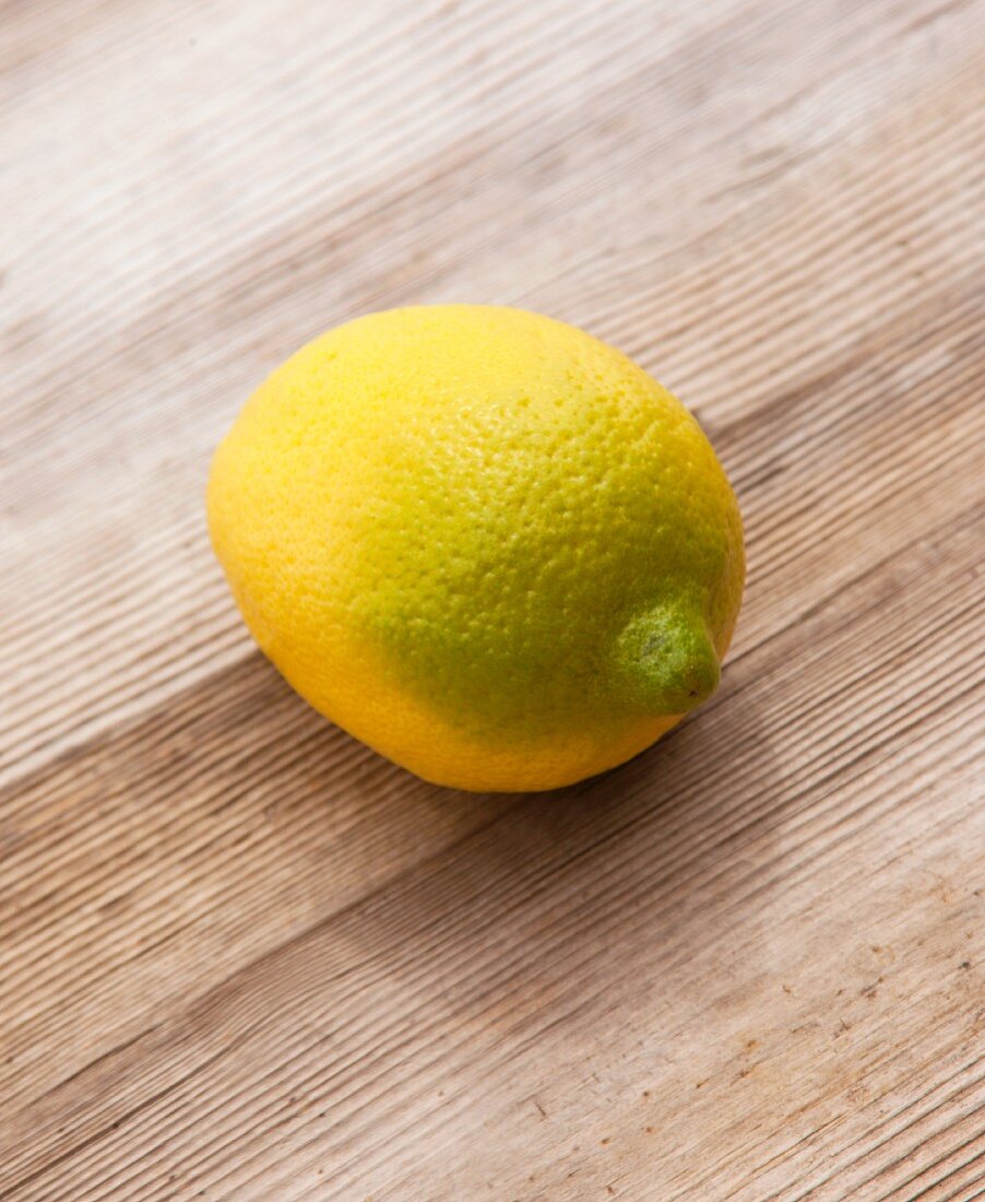 A combination of a lemon and a lime on an old wooden surface